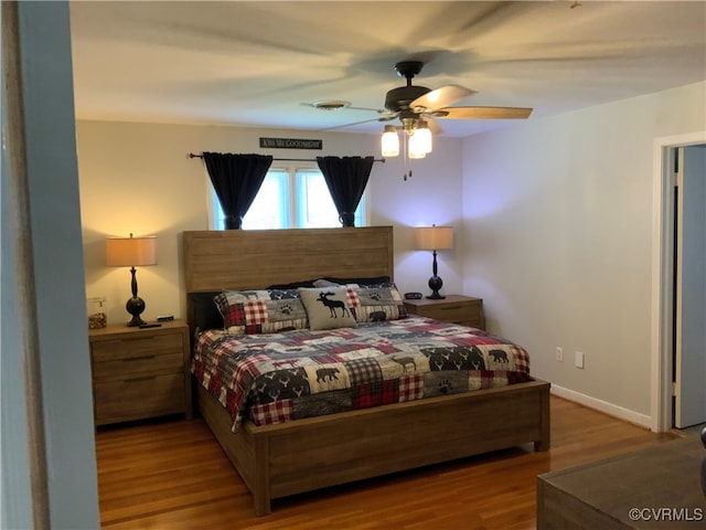 bedroom with visible vents, a ceiling fan, baseboards, and wood finished floors