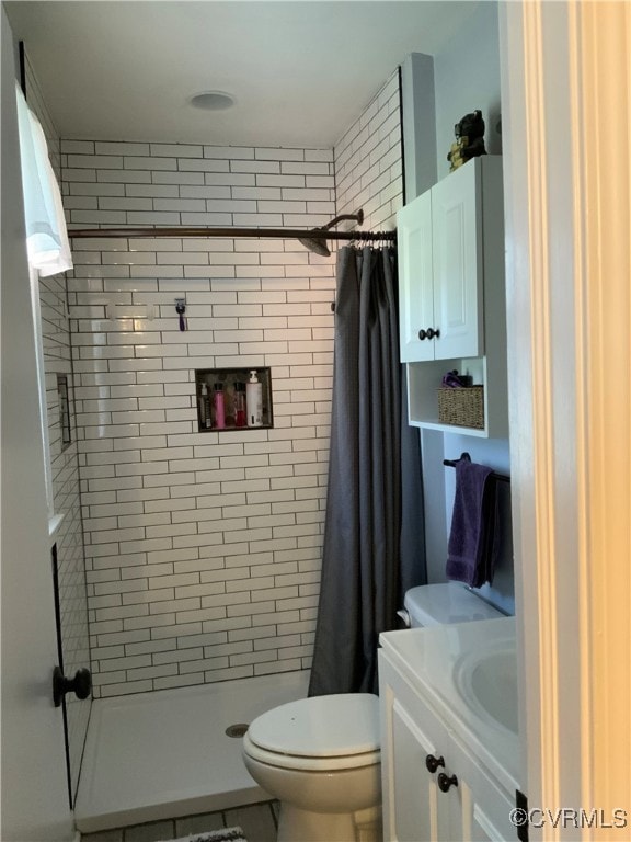 bathroom featuring a stall shower, toilet, and vanity