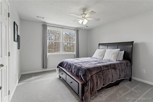 bedroom with visible vents, a ceiling fan, a textured ceiling, carpet flooring, and baseboards