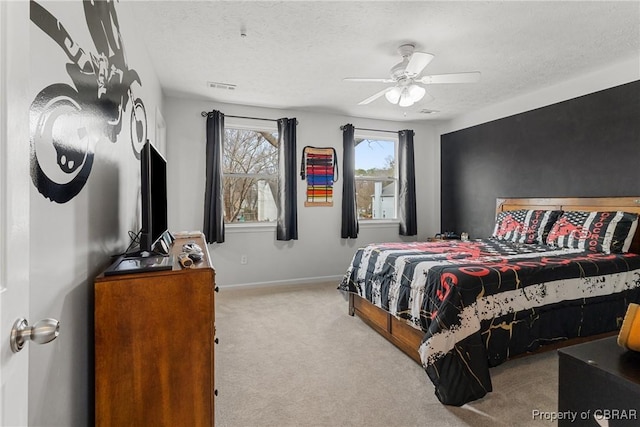 bedroom featuring visible vents, baseboards, carpet flooring, a textured ceiling, and a ceiling fan