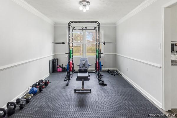 workout room featuring baseboards and ornamental molding