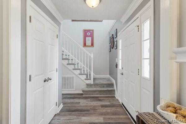 foyer entrance featuring stairs, wood finished floors, visible vents, and a healthy amount of sunlight