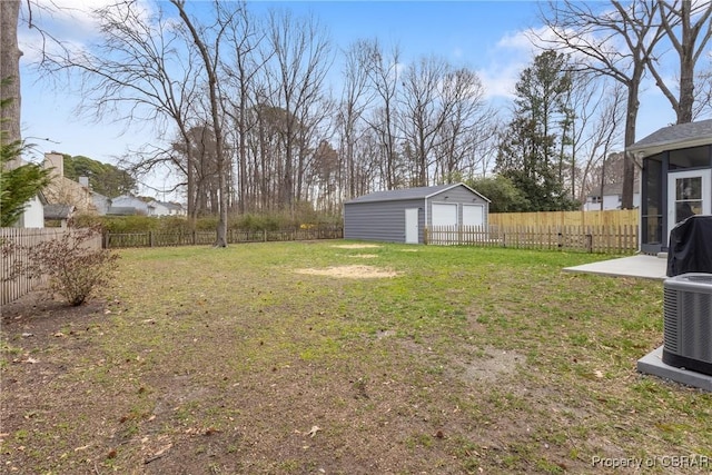 view of yard featuring an outbuilding, cooling unit, a fenced backyard, and a garage