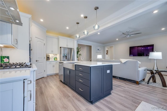 kitchen featuring a sink, white cabinetry, stainless steel appliances, light wood-style floors, and light countertops