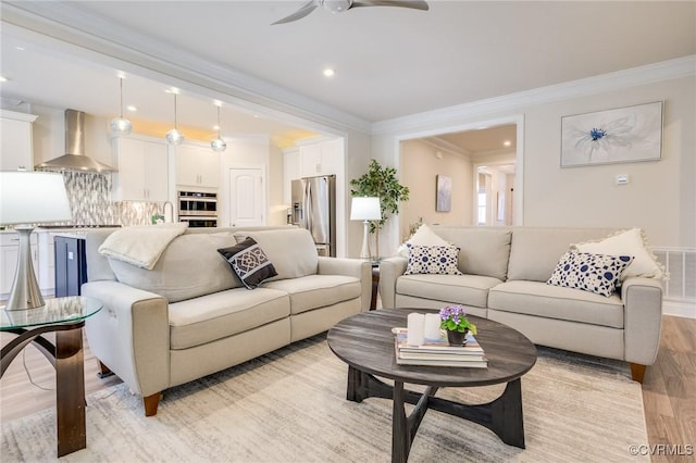 living room featuring light wood-type flooring, visible vents, a ceiling fan, recessed lighting, and crown molding