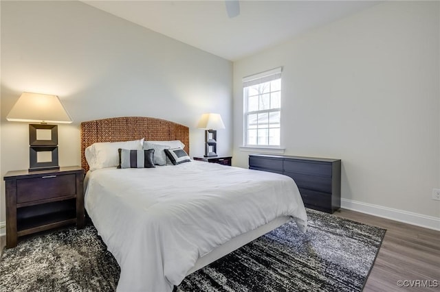 bedroom with a ceiling fan, vaulted ceiling, wood finished floors, and baseboards