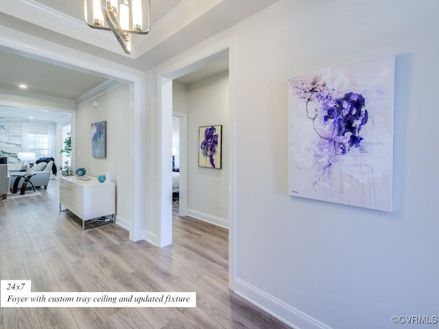 hallway featuring baseboards, wood finished floors, and ornamental molding