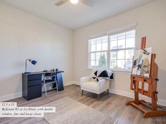 living area featuring a ceiling fan, wood finished floors, and baseboards