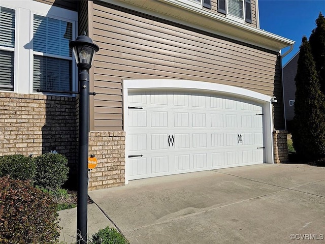 garage featuring concrete driveway