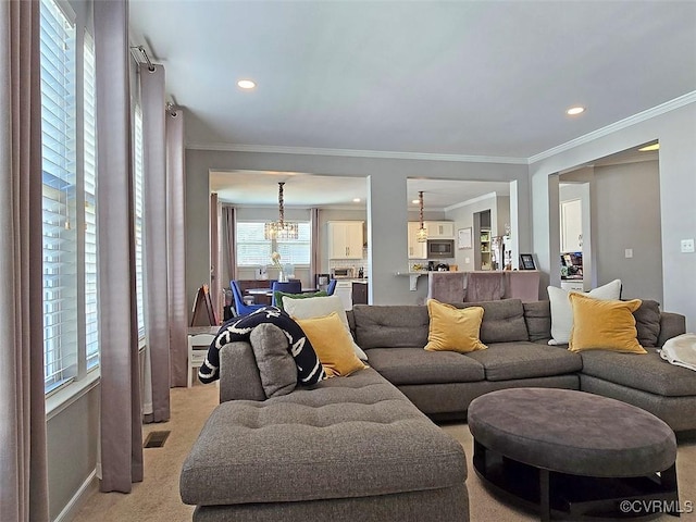 living area featuring recessed lighting, visible vents, ornamental molding, and a chandelier