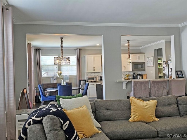 living area featuring an inviting chandelier, a toaster, and crown molding