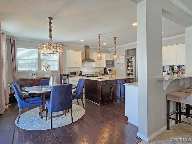 dining area featuring dark wood finished floors, recessed lighting, crown molding, and baseboards