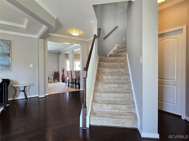 staircase featuring ornamental molding, baseboards, and wood finished floors