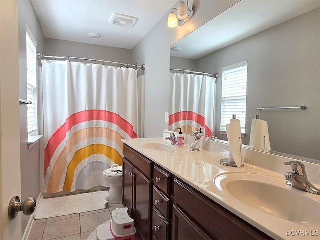 bathroom featuring a sink, visible vents, toilet, and tile patterned flooring