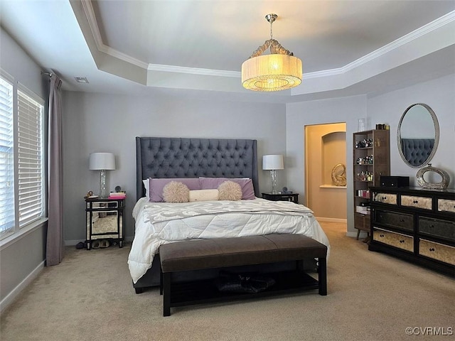 carpeted bedroom with baseboards, a tray ceiling, and ornamental molding