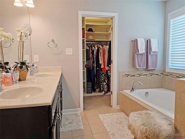 full bath featuring tile patterned floors, a spacious closet, double vanity, and a sink