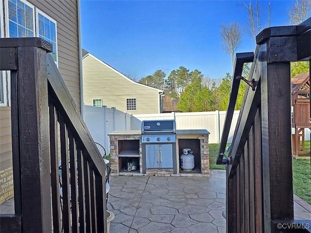 view of patio with area for grilling and a fenced backyard