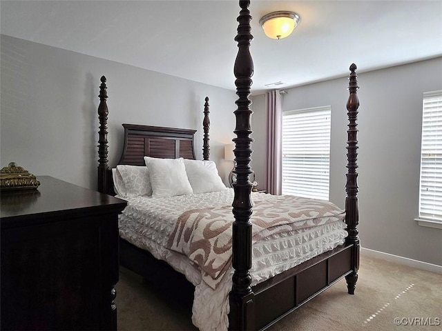 bedroom with baseboards, multiple windows, and light carpet