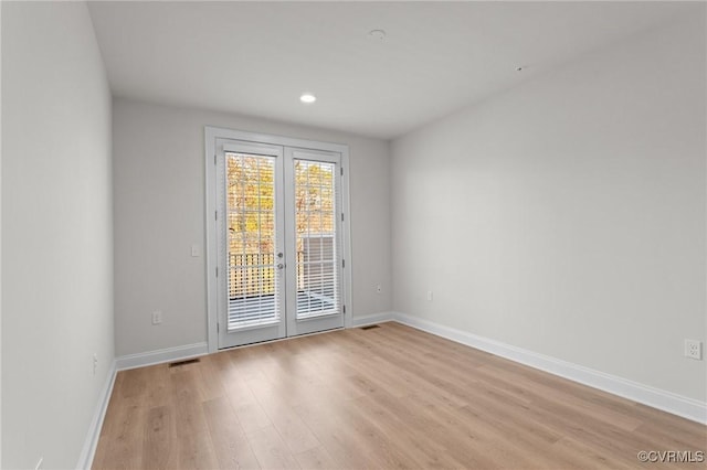 spare room featuring visible vents, baseboards, light wood finished floors, recessed lighting, and french doors