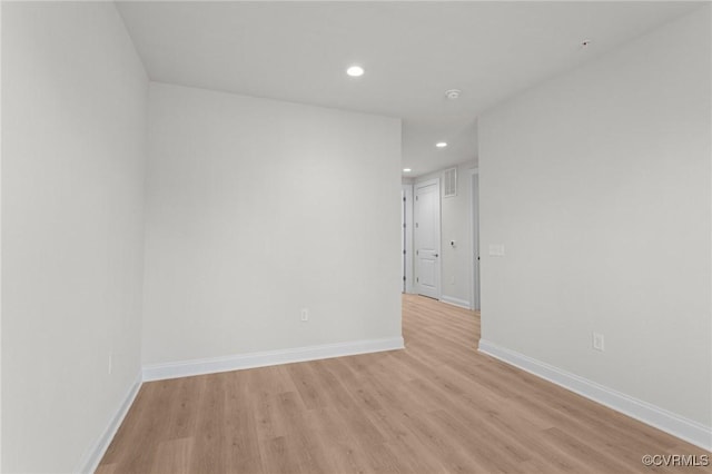 empty room with light wood finished floors, recessed lighting, and baseboards