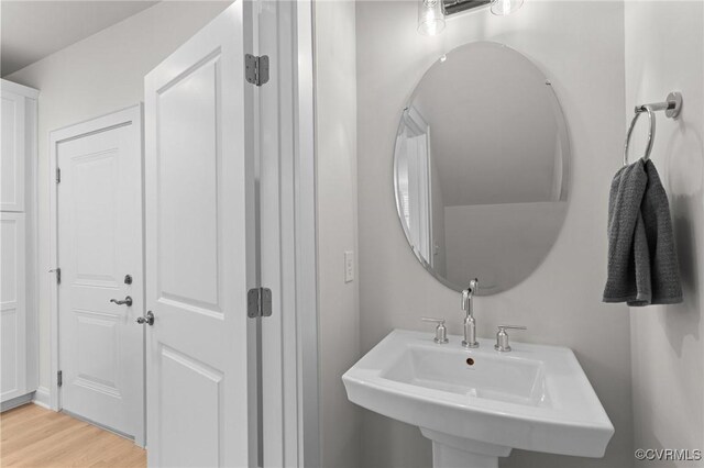 bathroom with wood finished floors and a sink