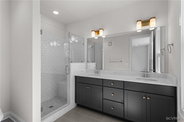 bathroom with tile patterned floors, double vanity, a shower stall, and a sink