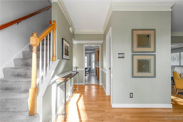 entryway featuring stairway, baseboards, light wood-style floors, and crown molding