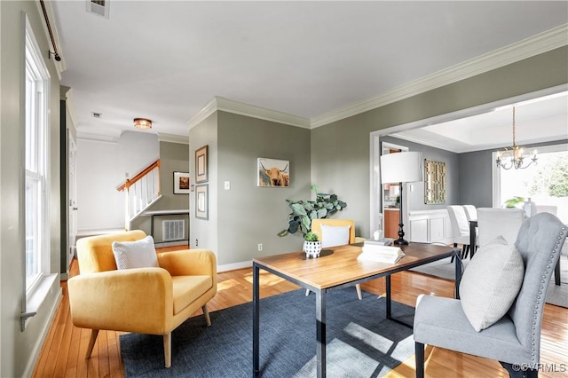 living area with light wood finished floors, visible vents, stairs, and an inviting chandelier