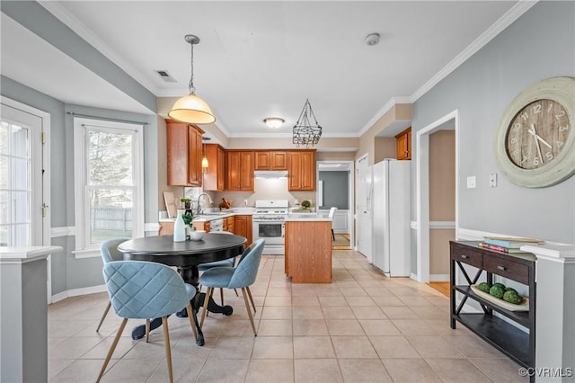 kitchen with under cabinet range hood, light countertops, light tile patterned flooring, white appliances, and a sink