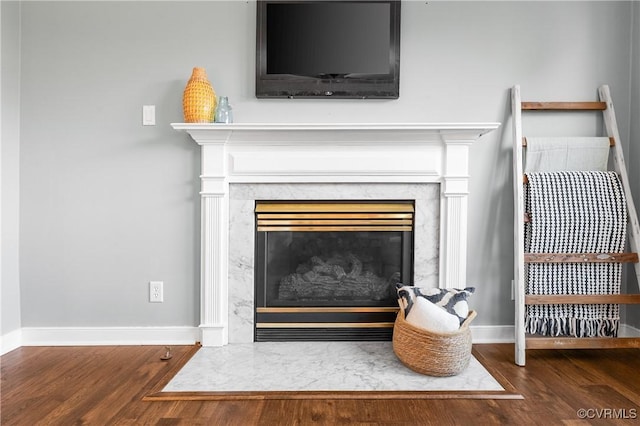 room details featuring wood finished floors, a fireplace, and baseboards