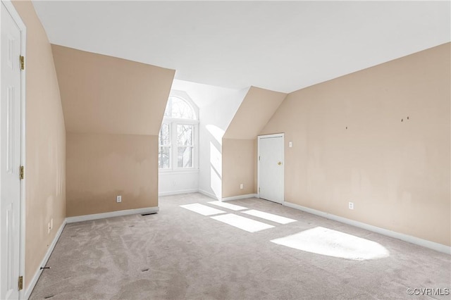 additional living space with baseboards, carpet, and vaulted ceiling