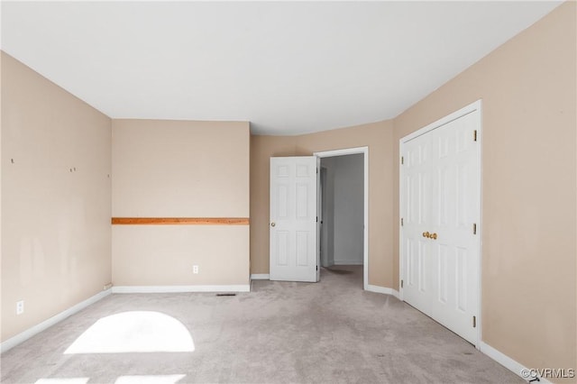 unfurnished bedroom with a closet, baseboards, and carpet floors