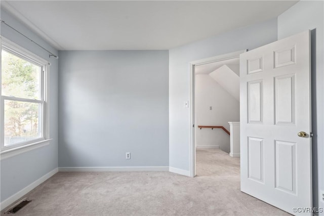 spare room featuring visible vents, light carpet, and baseboards