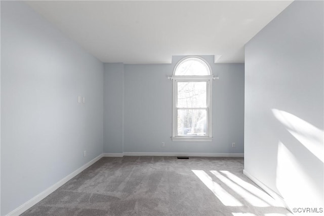 carpeted spare room featuring baseboards