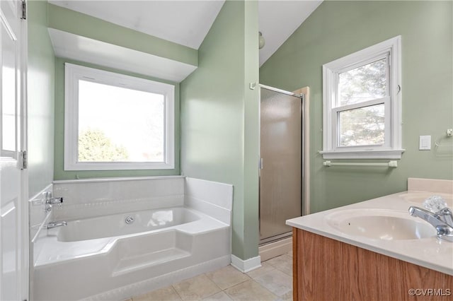 full bath featuring a garden tub, a stall shower, a sink, tile patterned flooring, and double vanity