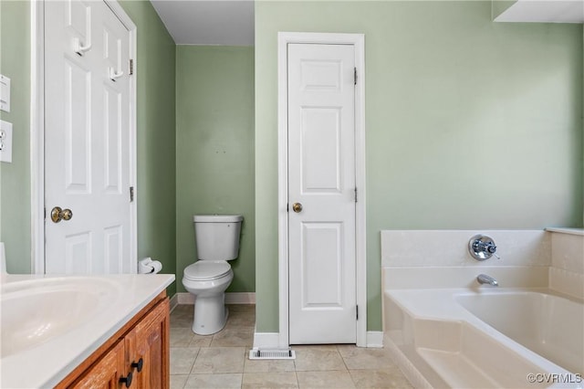 bathroom with toilet, tile patterned flooring, baseboards, a bath, and vanity