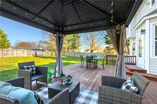 wooden deck with outdoor dining space, a yard, a fenced backyard, a gazebo, and an outdoor hangout area