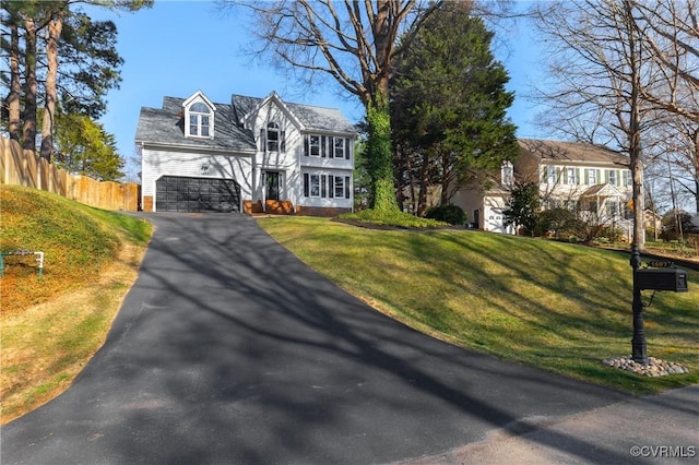 view of front of house with driveway, an attached garage, a front yard, and fence