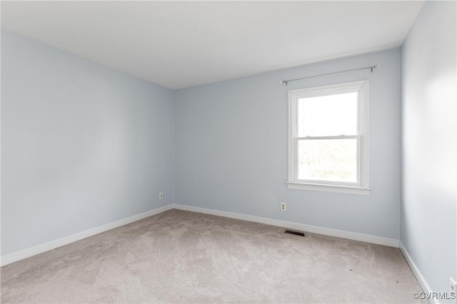 spare room featuring visible vents, baseboards, and light carpet