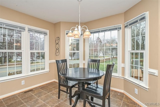 dining area featuring baseboards, visible vents, a wealth of natural light, and a chandelier