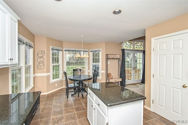 kitchen featuring french doors, baseboards, an inviting chandelier, and white cabinetry