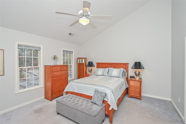 bedroom with vaulted ceiling, light colored carpet, visible vents, and baseboards