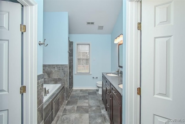 bathroom with a garden tub, toilet, visible vents, and a sink