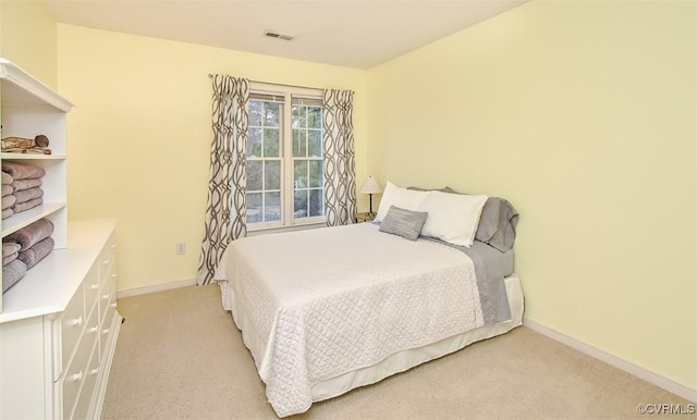 bedroom featuring visible vents, light carpet, and baseboards