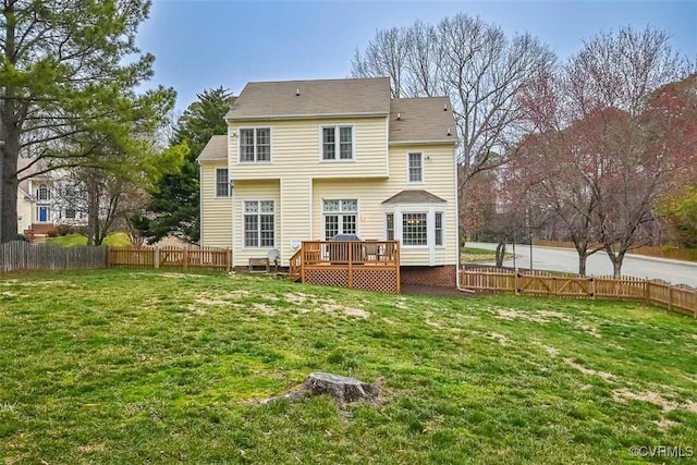 back of house featuring a lawn, a wooden deck, and a fenced backyard