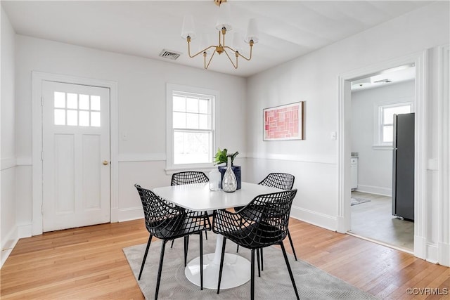 dining space with a wealth of natural light, visible vents, baseboards, and light wood-style flooring