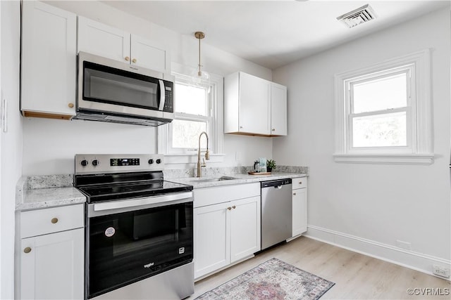 kitchen featuring visible vents, white cabinets, appliances with stainless steel finishes, and plenty of natural light