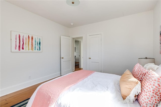 bedroom with baseboards and wood finished floors