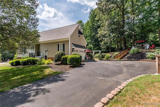 view of home's exterior featuring aphalt driveway, a yard, and a garage