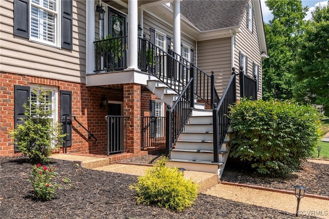 entrance to property with brick siding and roof with shingles